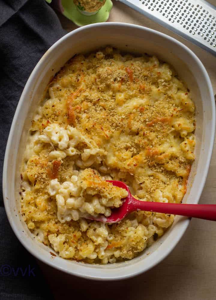 overhead shot of baked mac and cheese with red silicone spoon inside the white casserole dish