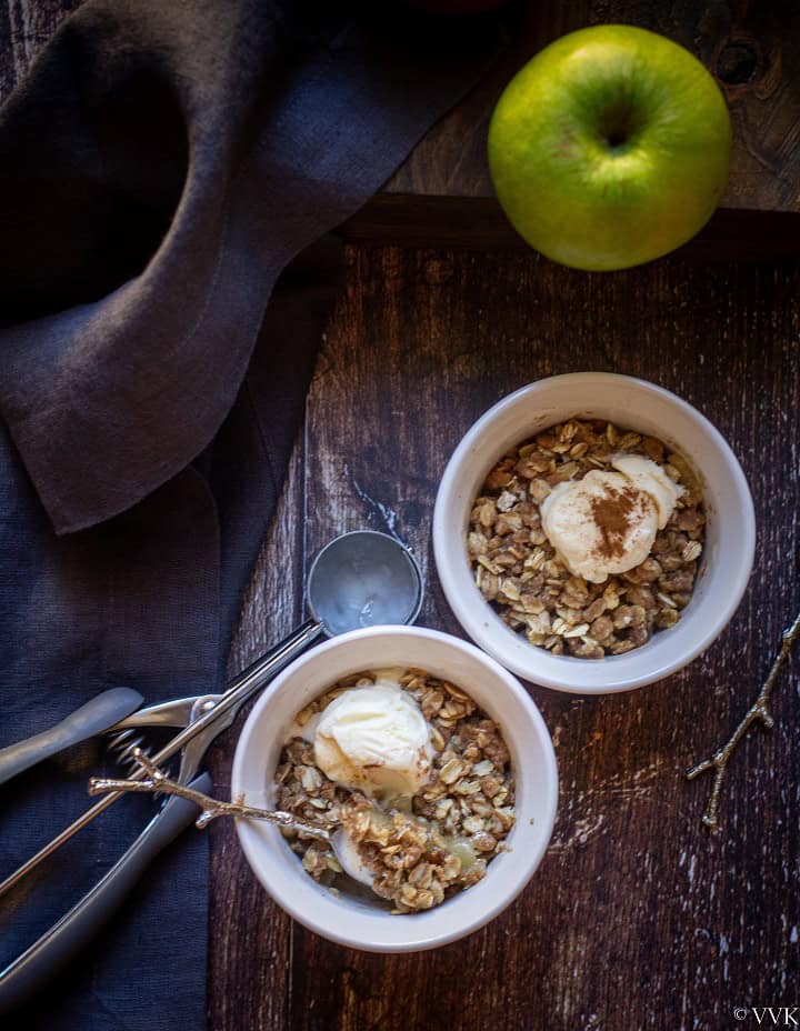 apple crisp served with ice cream in a ceramic bowls topped with icecream