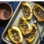 roasted acorn squash with pesto and pinenuts with text overlay for pinterest