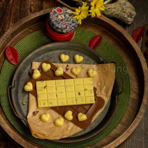 square image of homemade white chocolates layers on a wooden and rustic tray