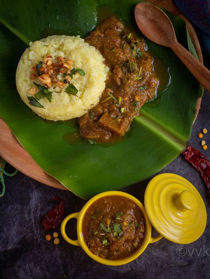 brinjal gothsu served in yellow casserole and plate of pongal and gothsu on the back