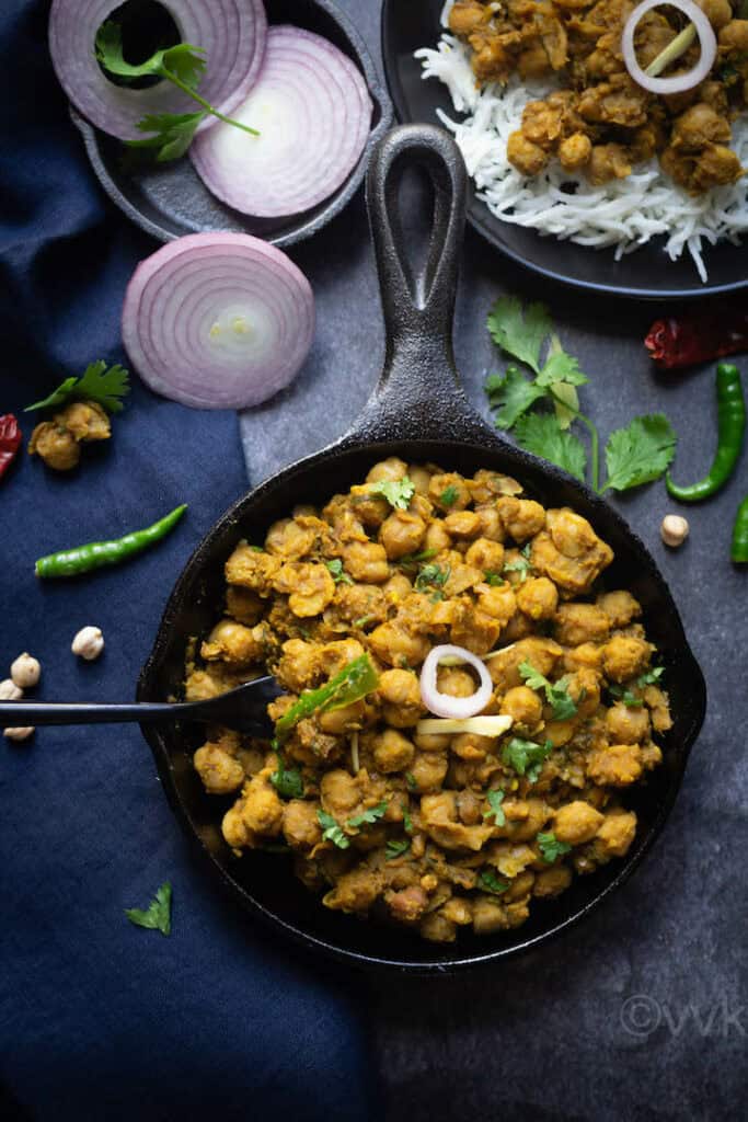 pindi chole served in cast iron skillet with onions on the side