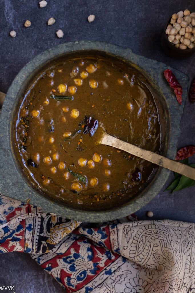 overhead shot of kadalai kuzhambu served in kalchatti