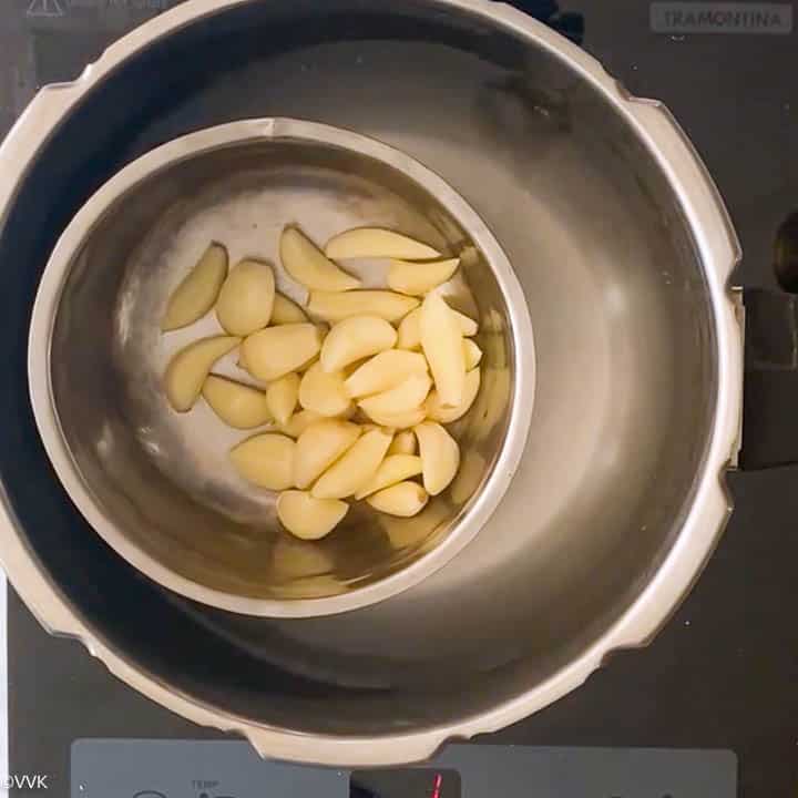 adding garlic to the inner pot of the pressure cooker