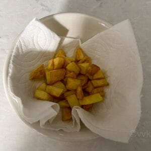 fried potatoes placed on a kitchen towel for draining