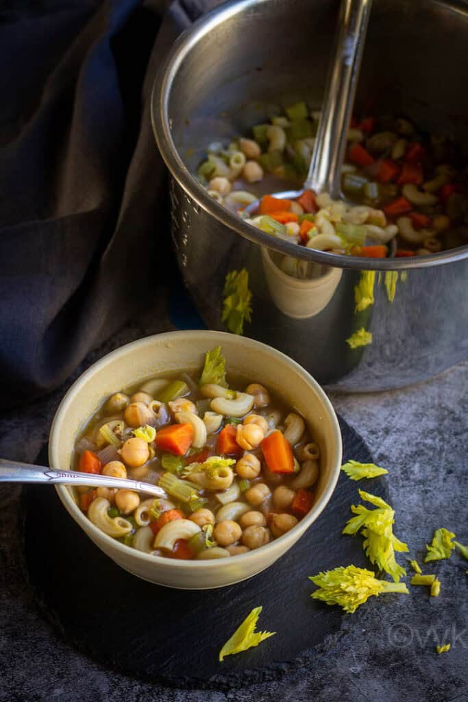 cajun chickpeas soup served in white bowl with instant pot placed behind wrapped with gray fabric