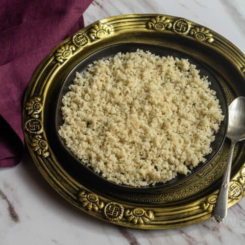 square image of barnyard millet placed in black plate on top of golden plate with purple fabric on the side