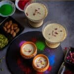 thandai served in kulhad and glass ware garnished with nuts and saffron