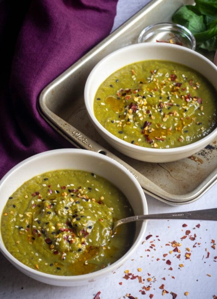 square image of asparagus soup served in two bowls