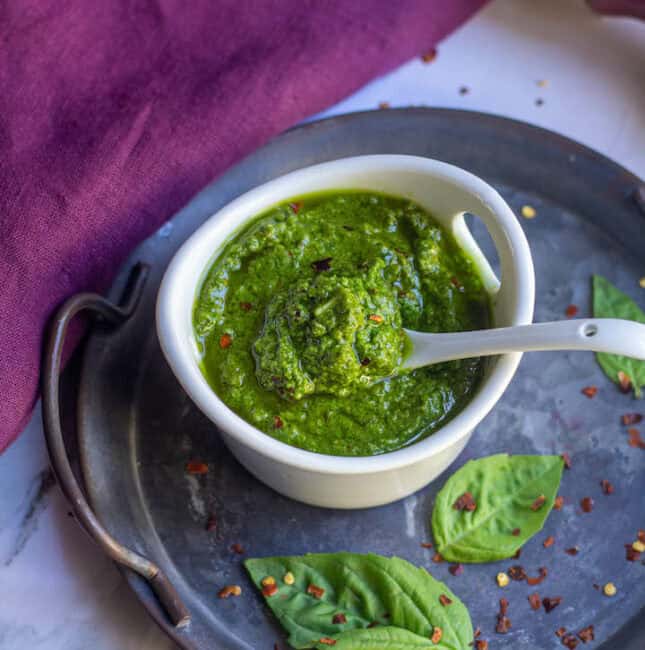 fresh pesto in a white bowl with a spoon inside