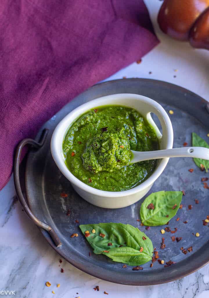 fresh pesto in a white bowl with a spoon inside