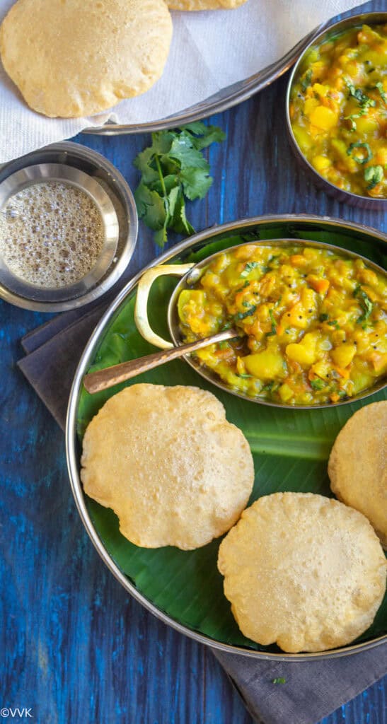 poori served with potato masala in a plate lined with banana leaf and coffee on the side