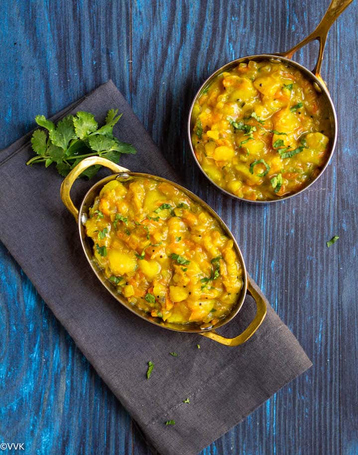 overhead shot of poori bhaji served in two copper ware bowls with cilantro as garnish