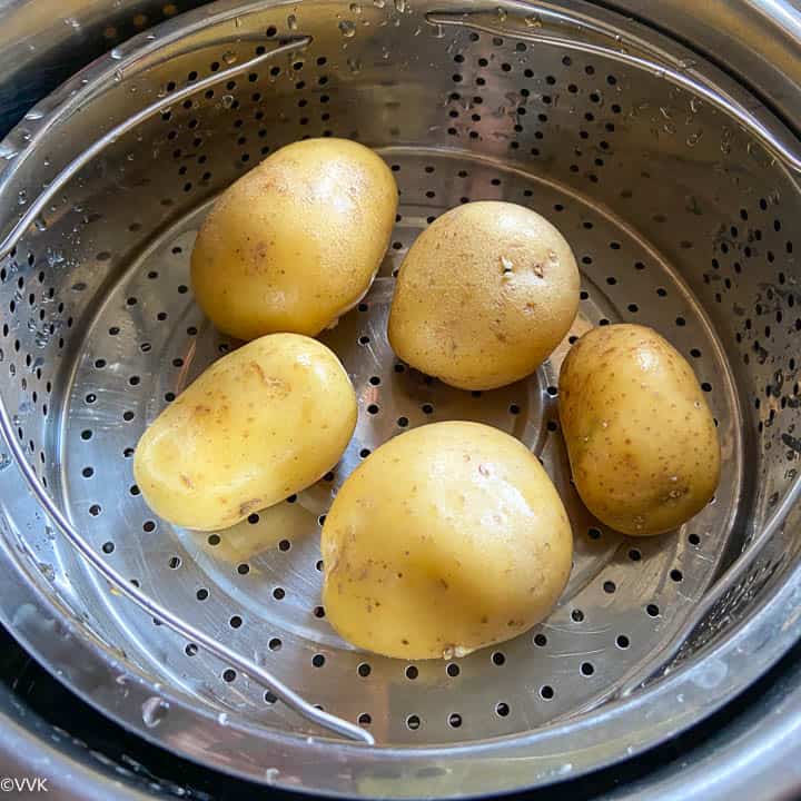 adding potatoes to the steamer rack of Instant Pot