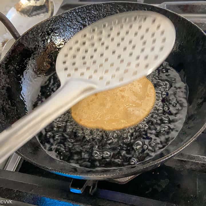 pressing the poori so that it puffs up