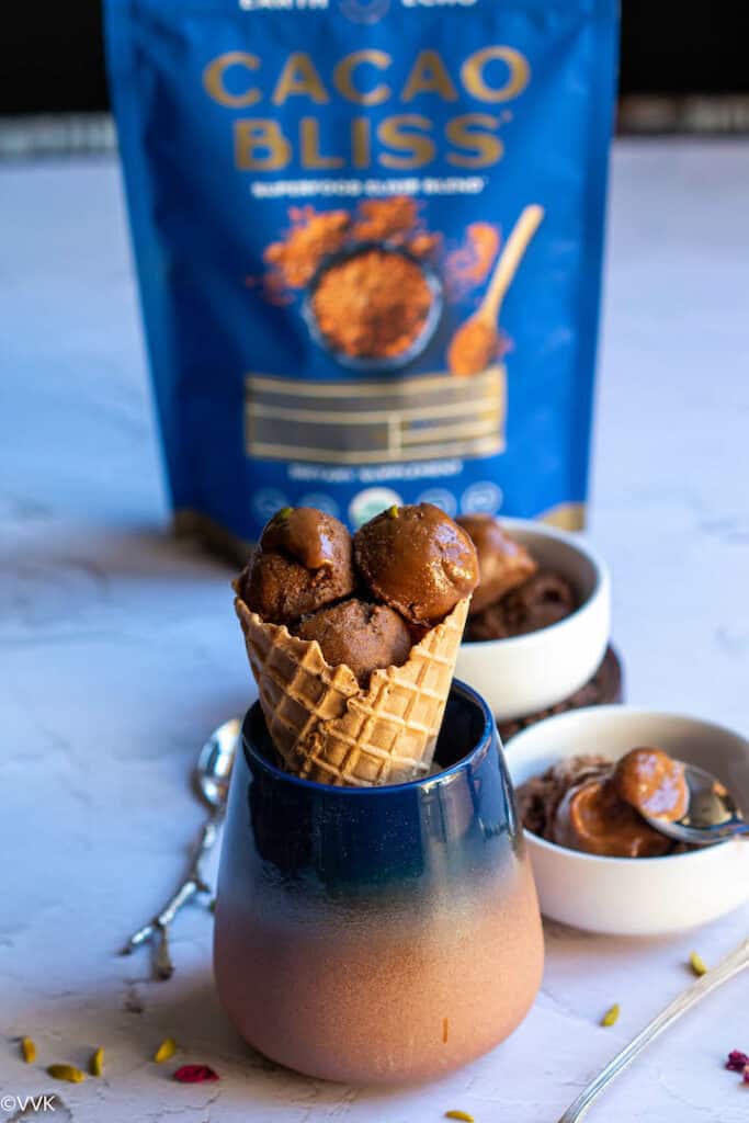 chocolate banana ice cream served in waffle cone place in blue cup with some ice cream in white bowl