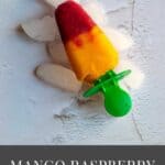 square image of mango raspberry popsicle placed on icebed with text overlay for pinterest