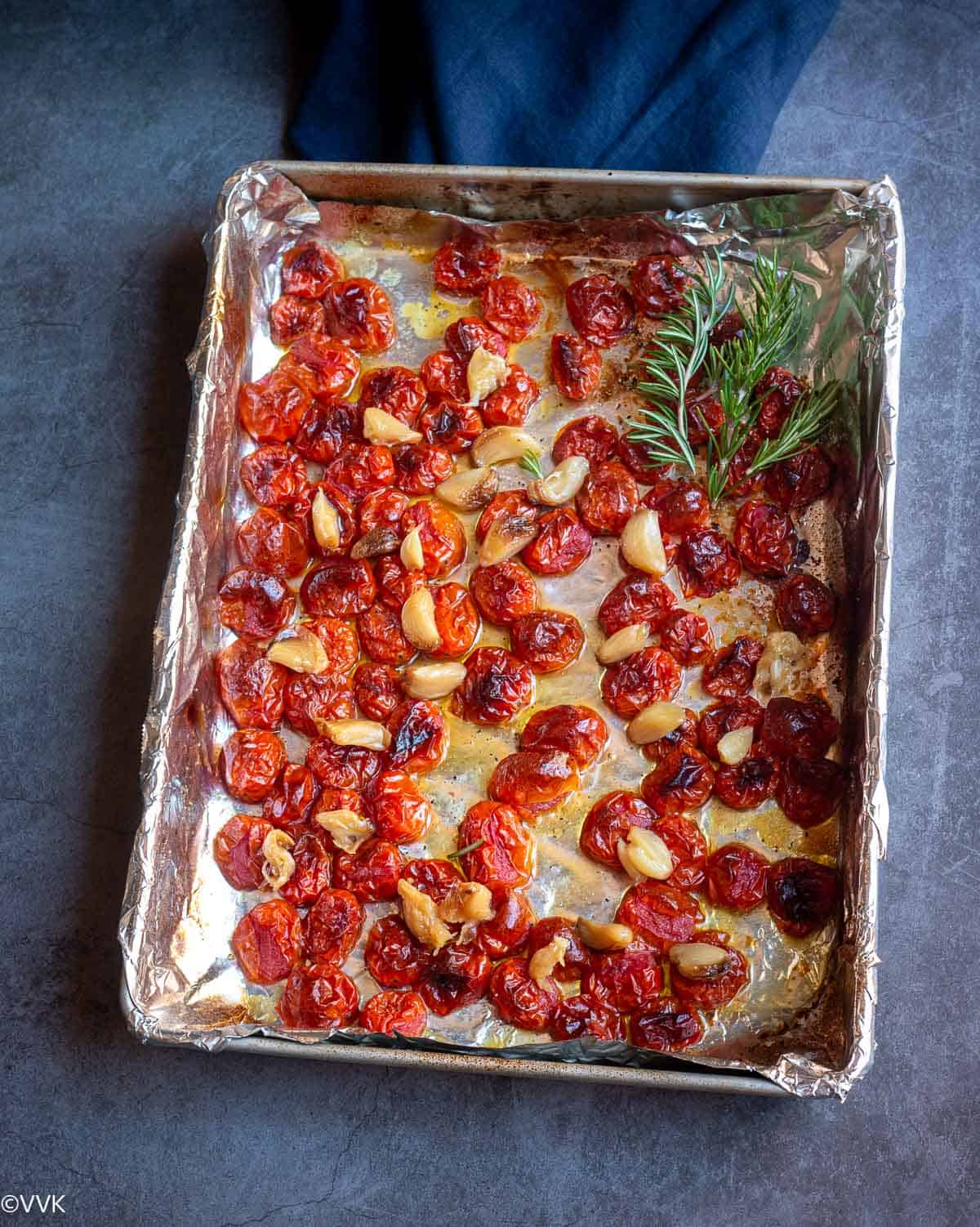 oven roasted tomatoes and garlic placed on baking tray