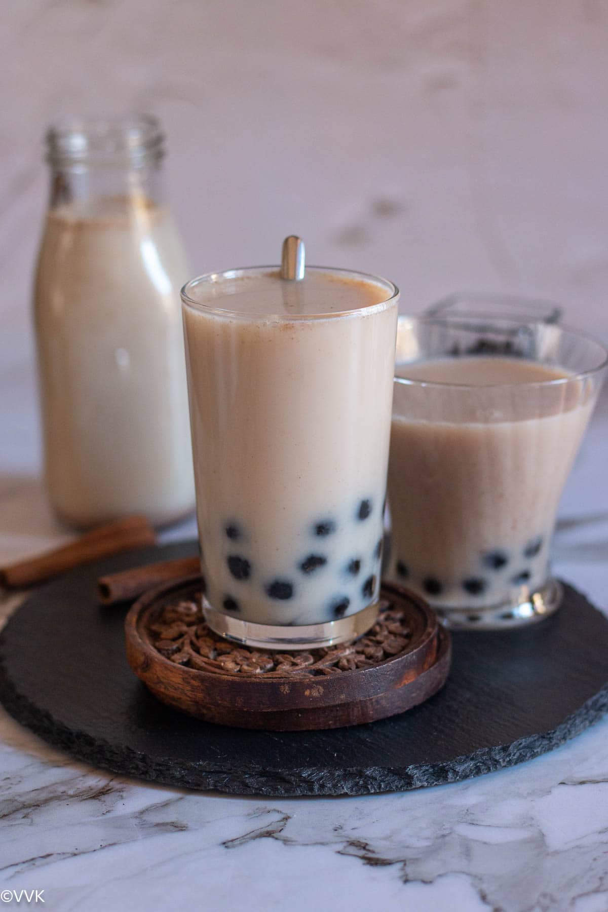 horchata served in tall glass with spoon inside placed on wooden coaster