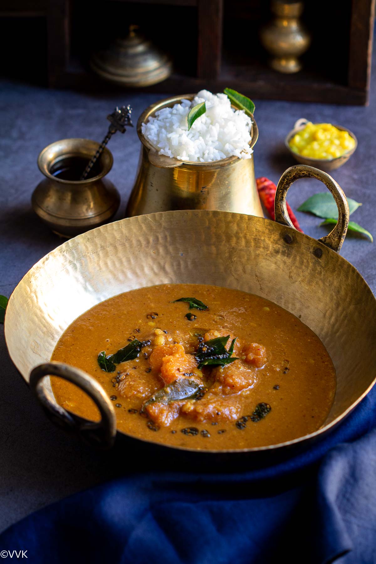 arachuvitta sambar served in a kadai with a side of rice, toor dal and ghee in a traditional set up