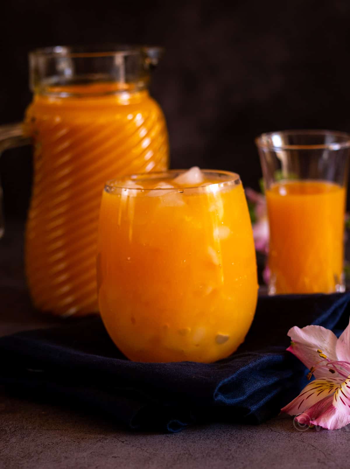 mango juice served in tall glass with the concentrate behind