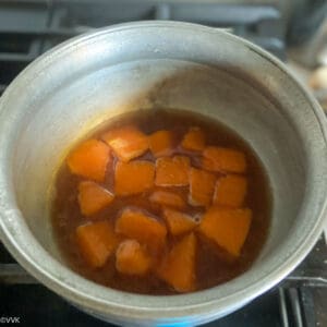 adding tamarind water and salt and cooking the pumpkin
