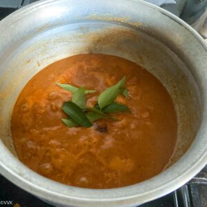 adding jaggery and curry leaves to the sambar