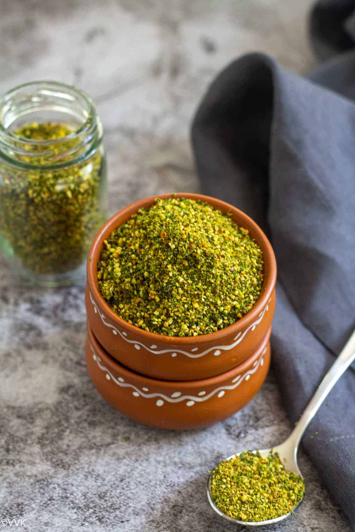 cilantro podi served in terracotta bowl and in a bottle on the side