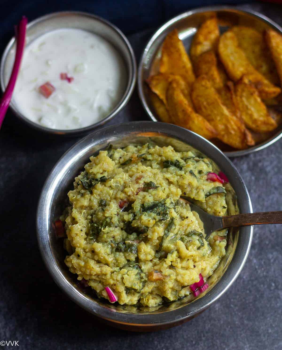 overhead shot of keerai sadam served with potato wedges and raita