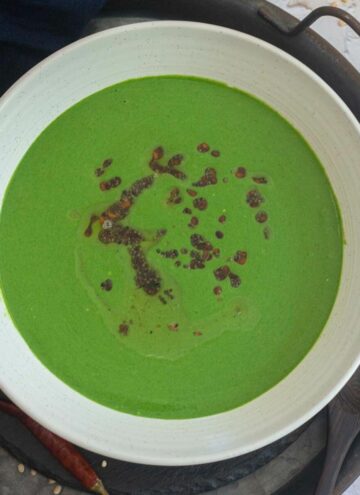 square image of spinach raita in a white bowl
