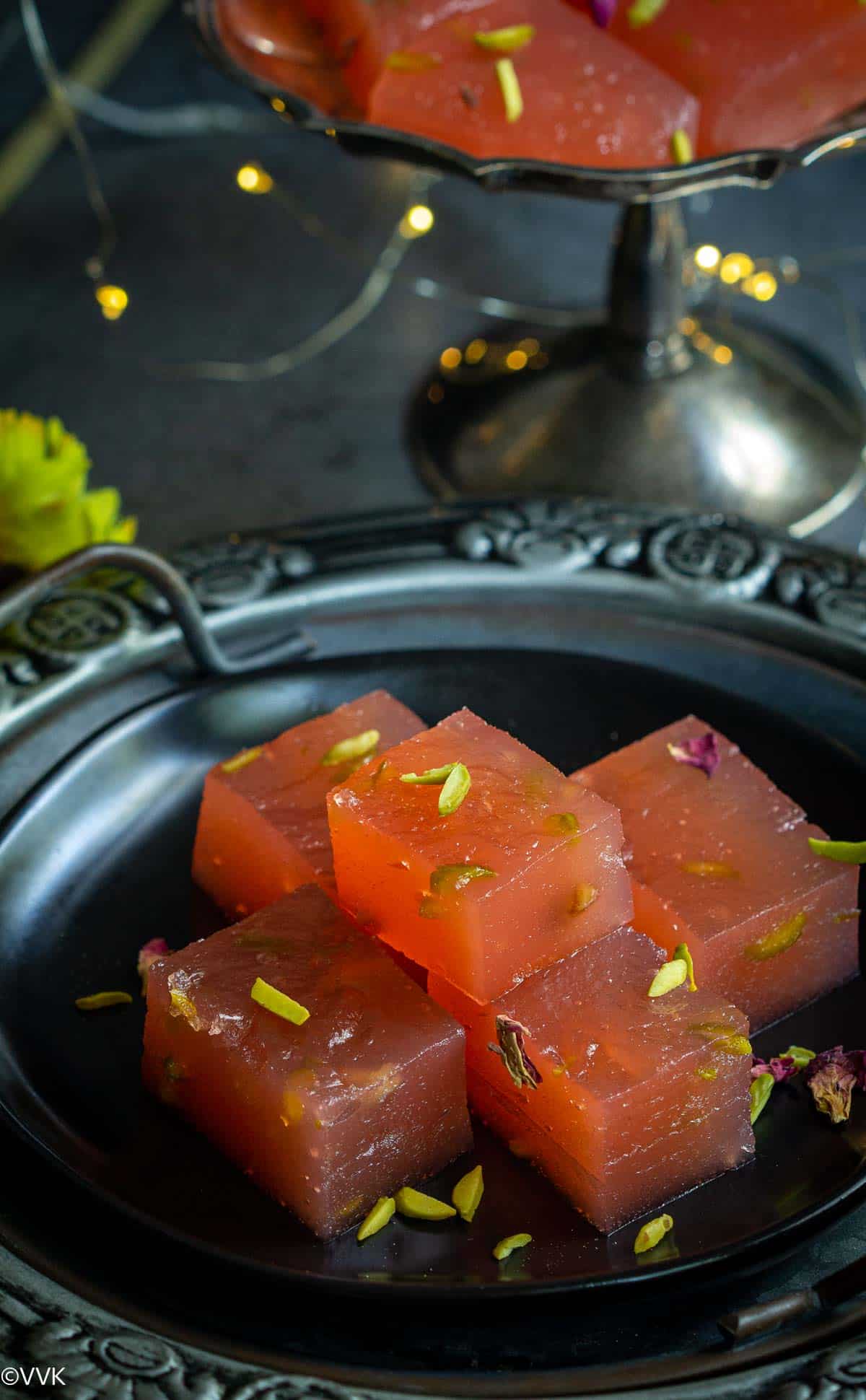 karacha halwa pieces stacked on a tray with light on the back ground