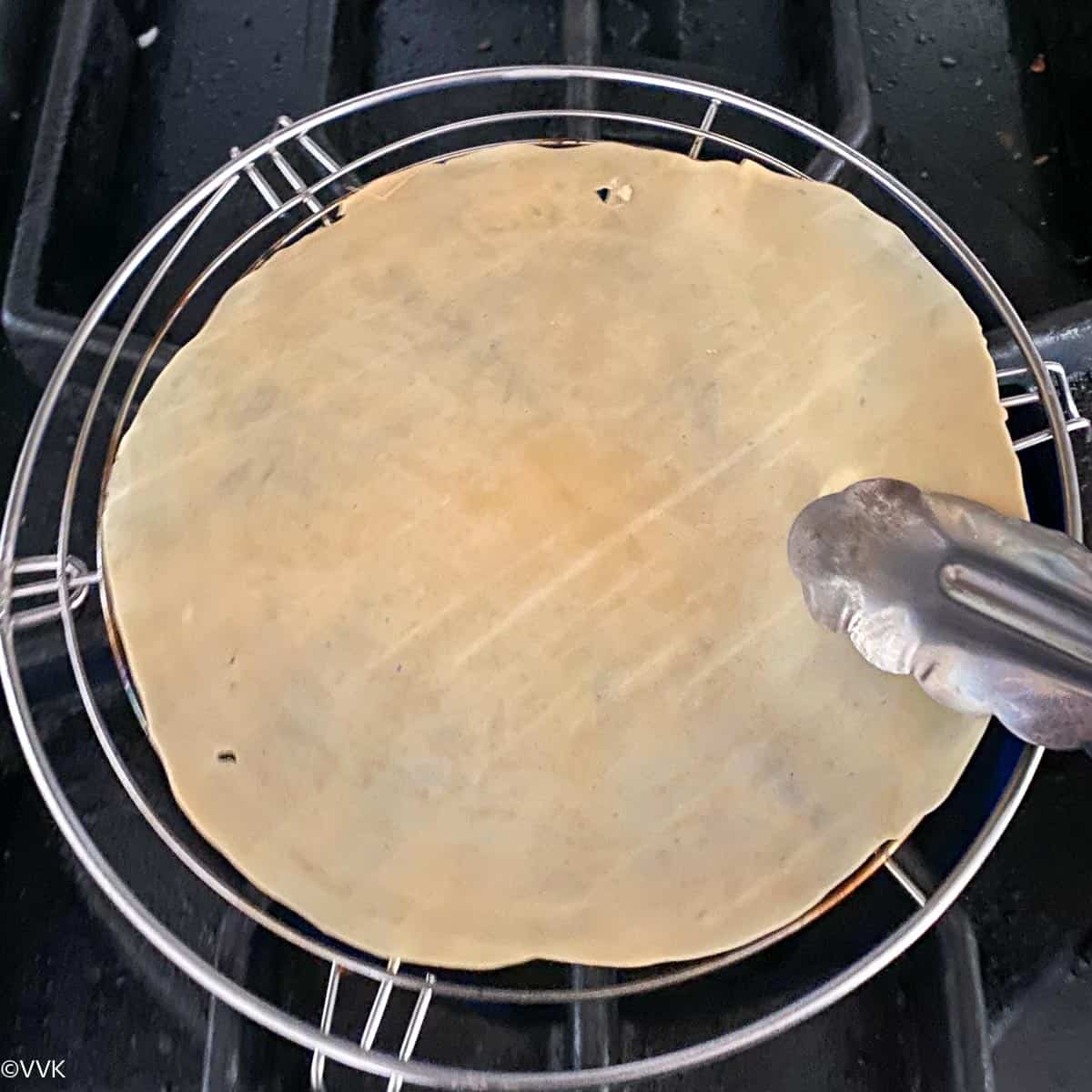 roasting papad on stove top with papad jali