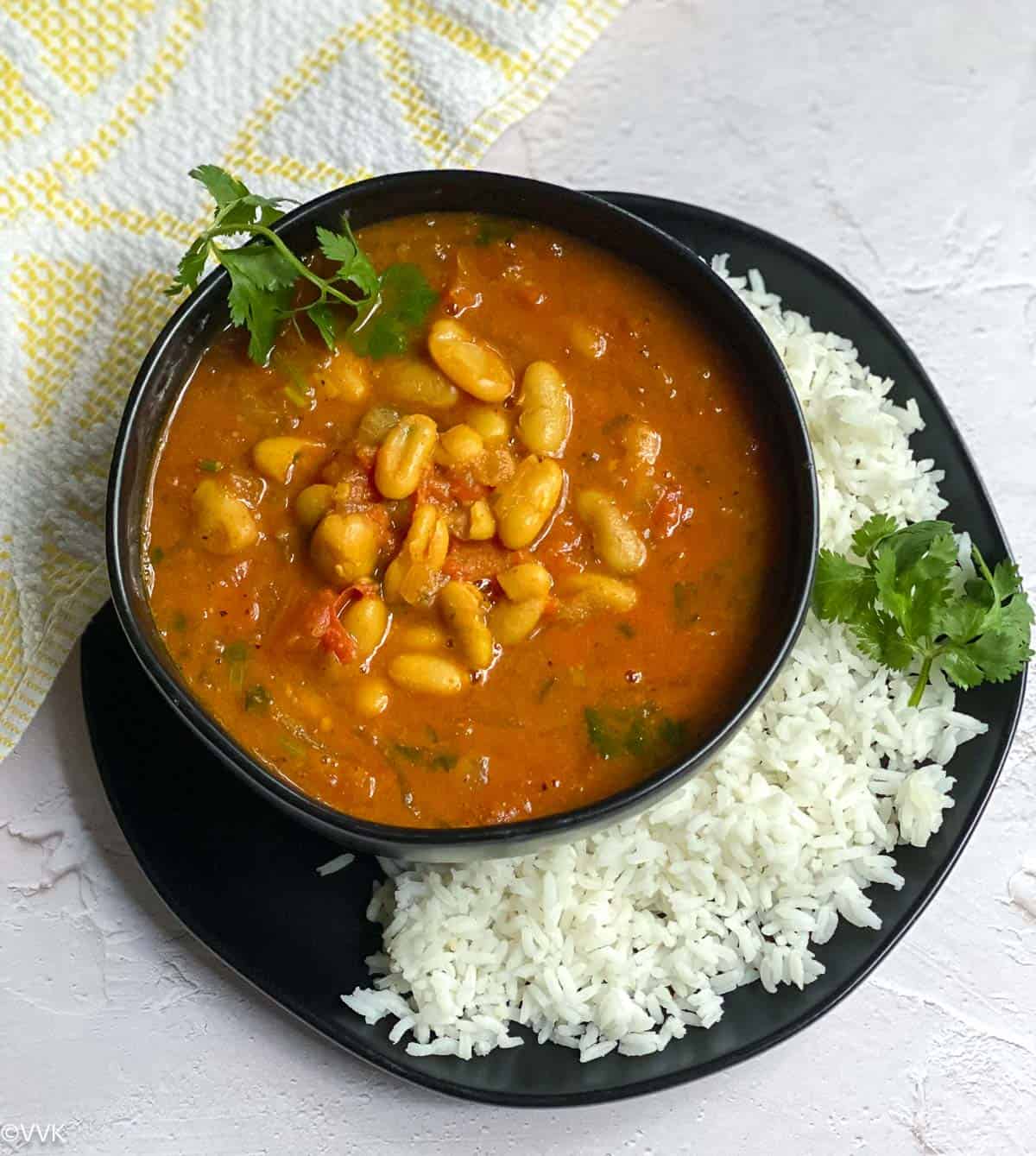 instant pot loubia served in black bowl with rice on a plate