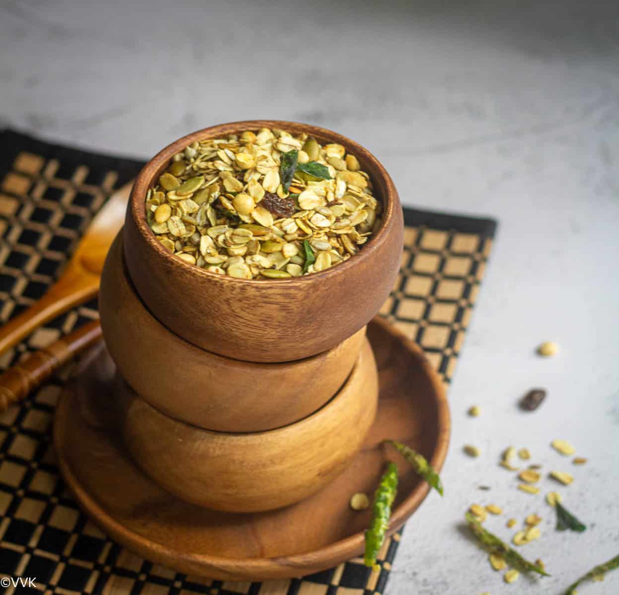 oats namkeen served in stacked up wooden bowl placed on a mat