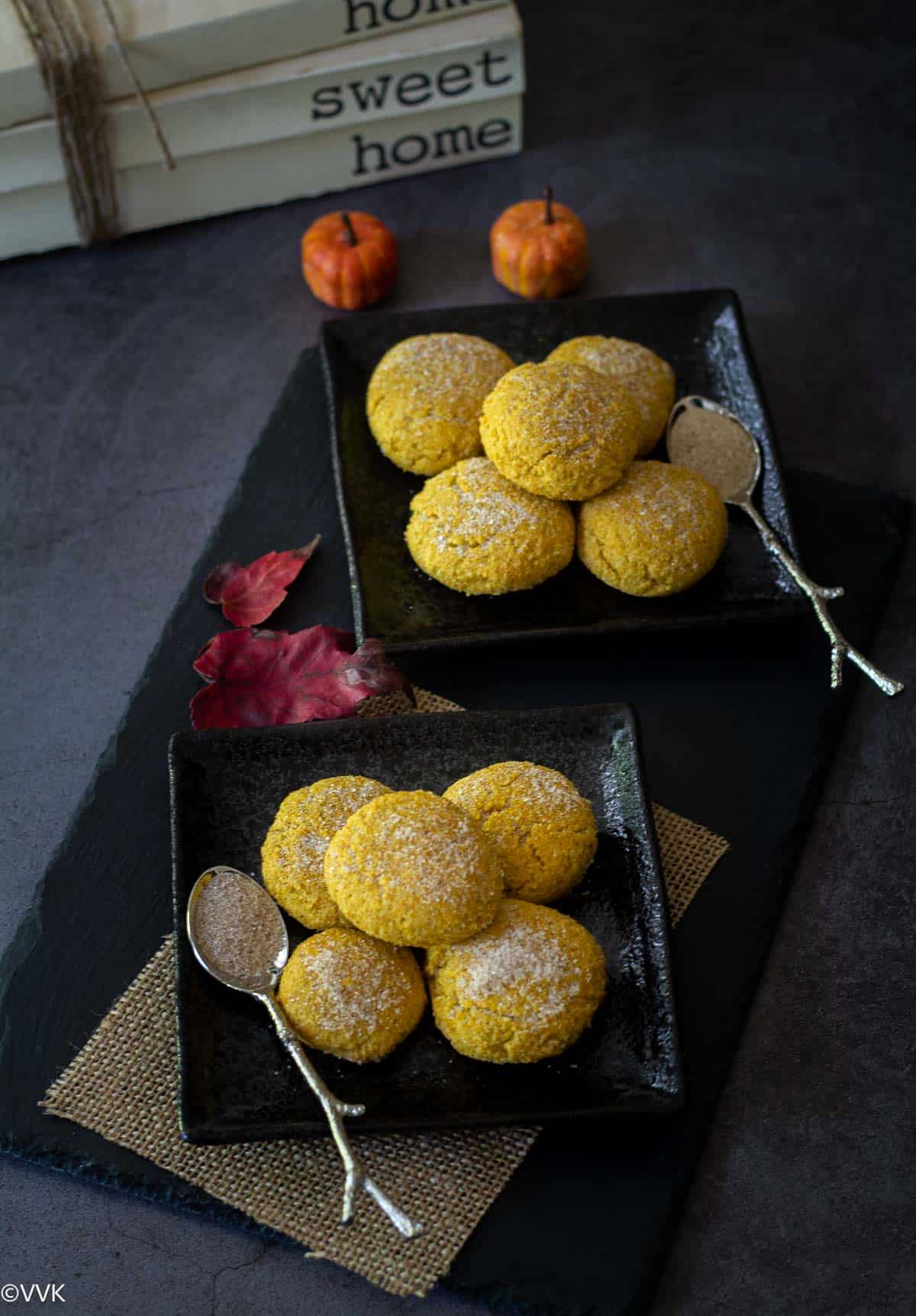 pumpkin spice cookies on two plates with sugar on the side