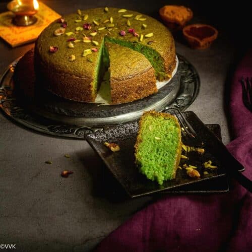 square image of paan cake with a slice kept on a black plate and diya on the side