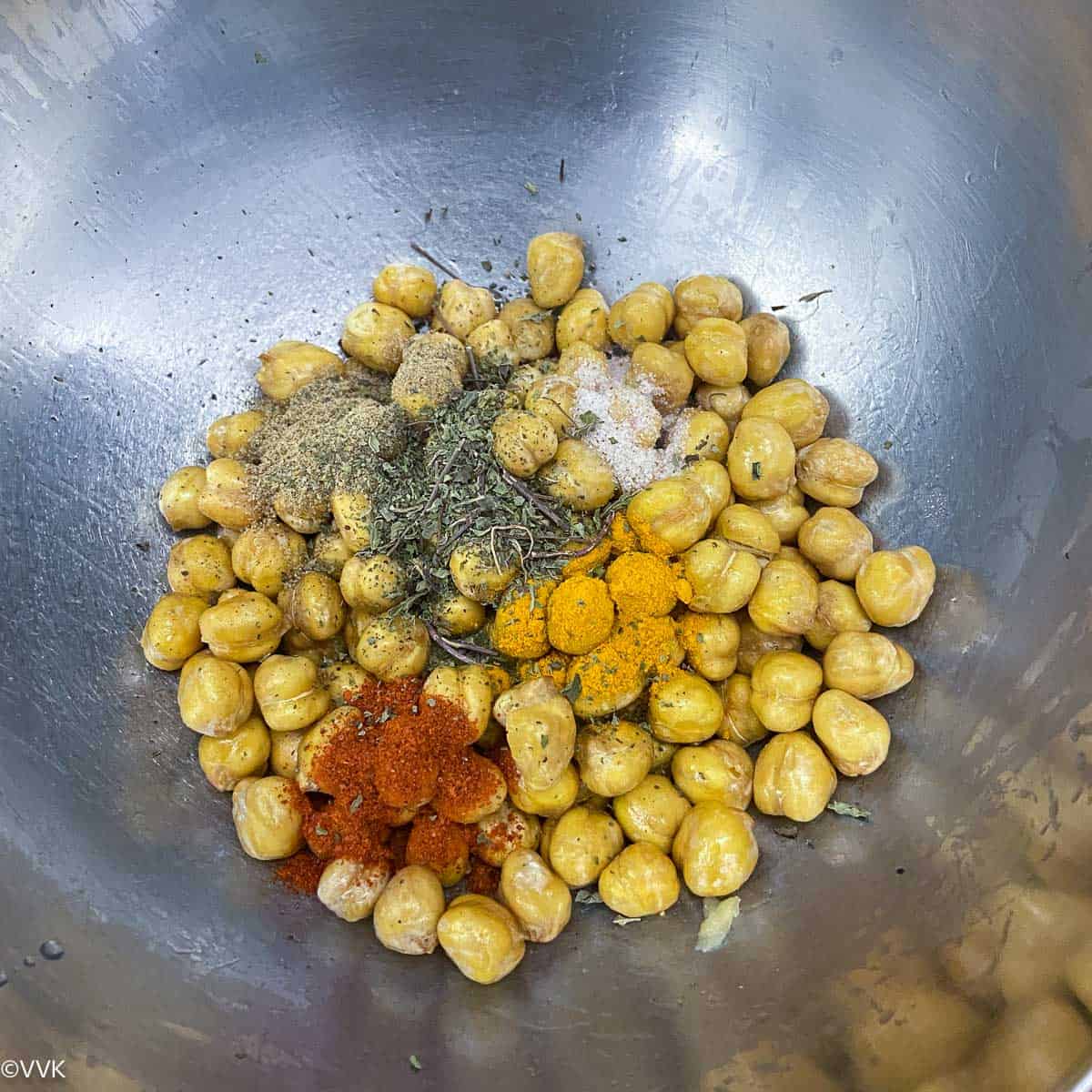 adding spices to partially roasted chickpeas