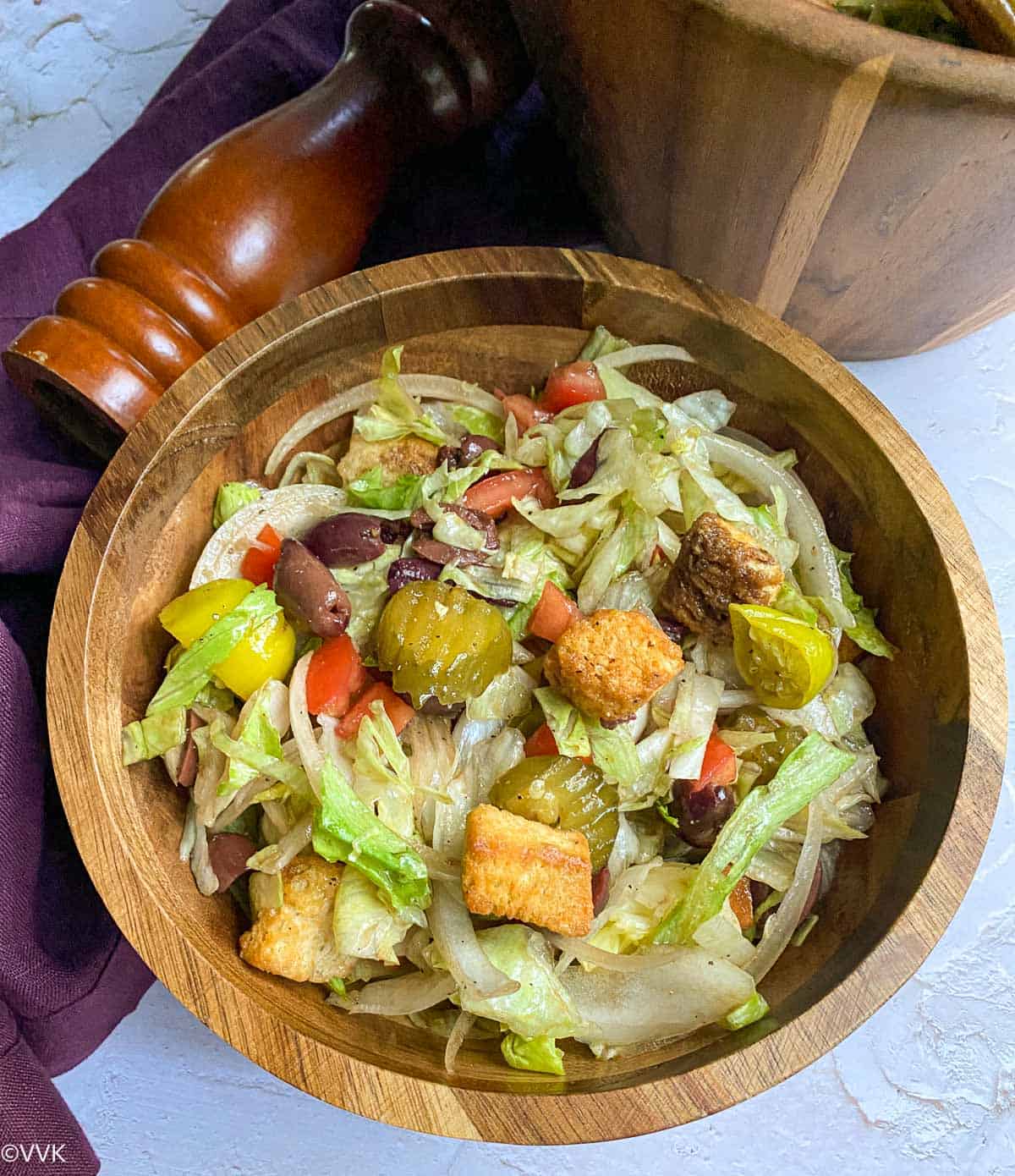 close up shot of salad served in round wooden bowl