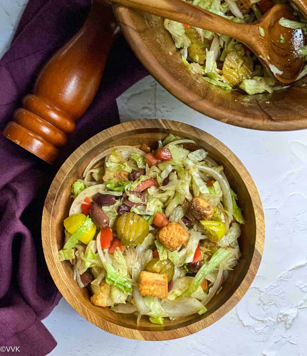 overhead shot of olive garden style garden salad served in two wooden bowls