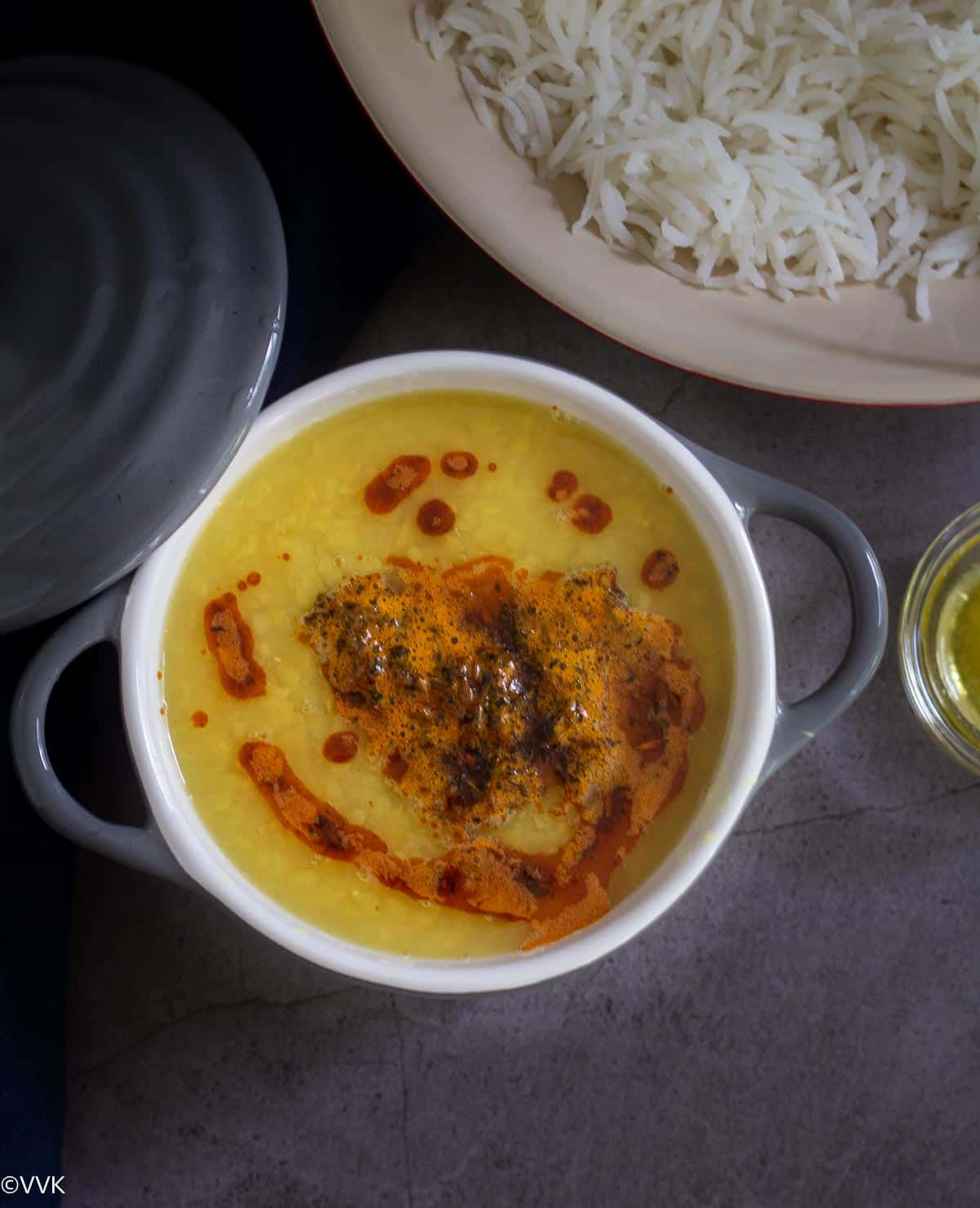 overhead shot of dal tadka with rice and ghee on the side