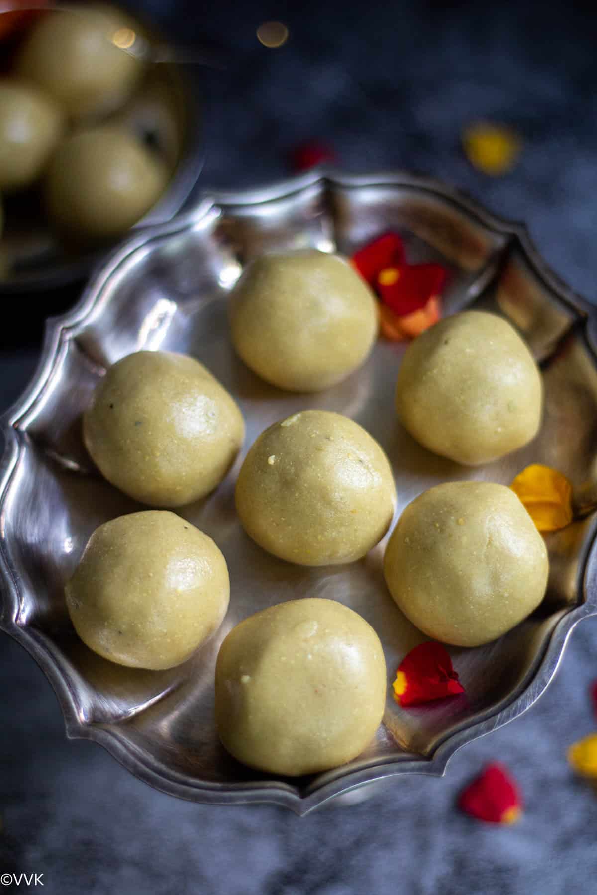close up overhead shot of maa ladoo with rose petals on the side as garnish