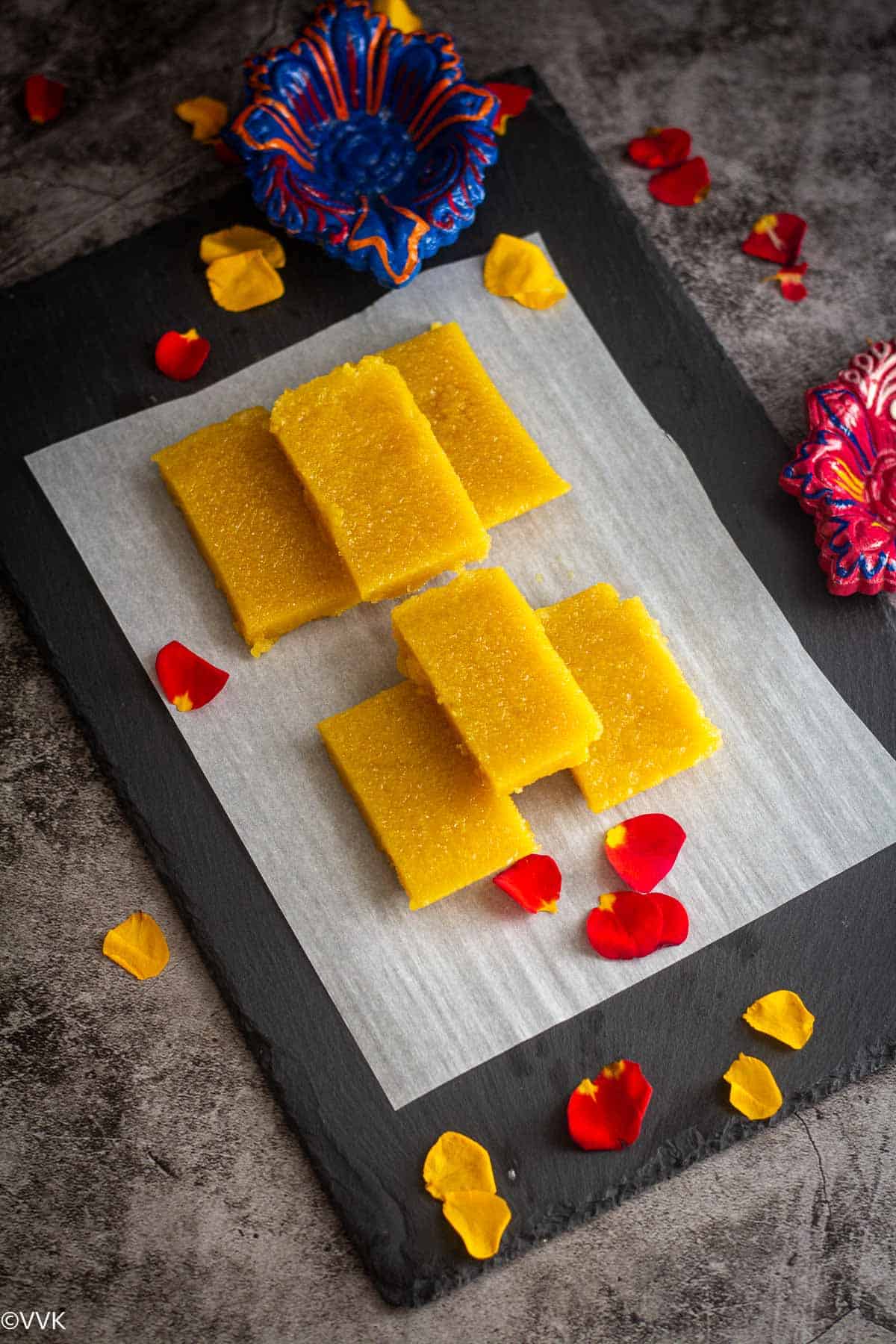 overhead shot of microwave mysore pak with rose petals as decor on the side