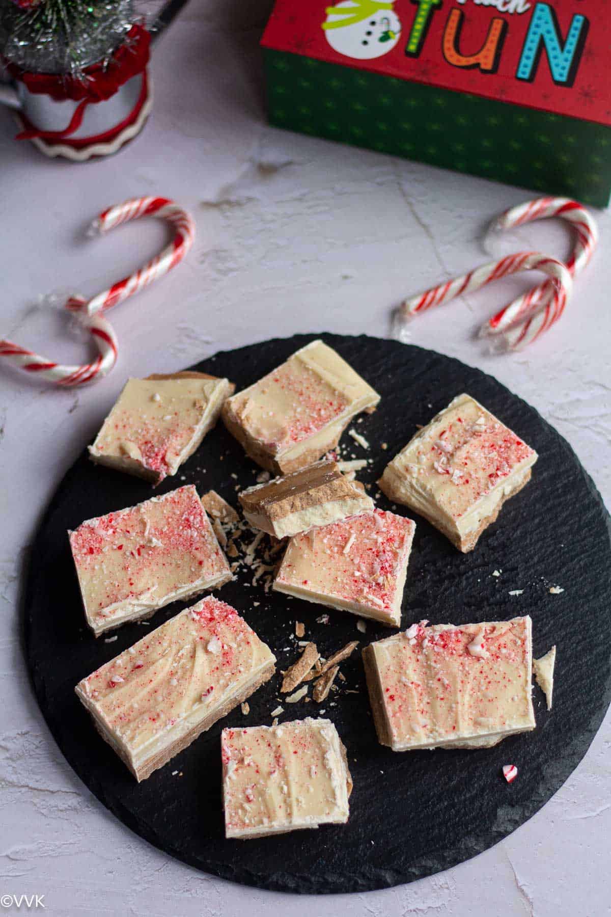 homemade peppermint bark served in black slateboard with candy canes on the side