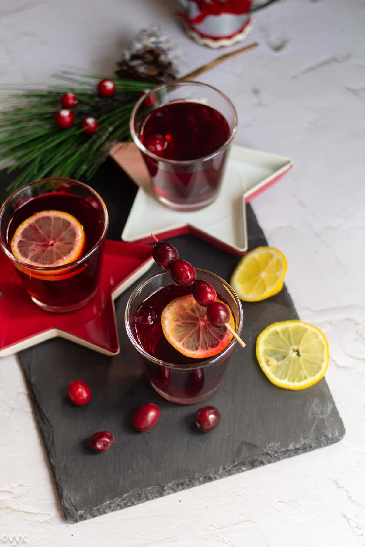 holiday special mocktail served in slate board with lemon wedges and cranberries