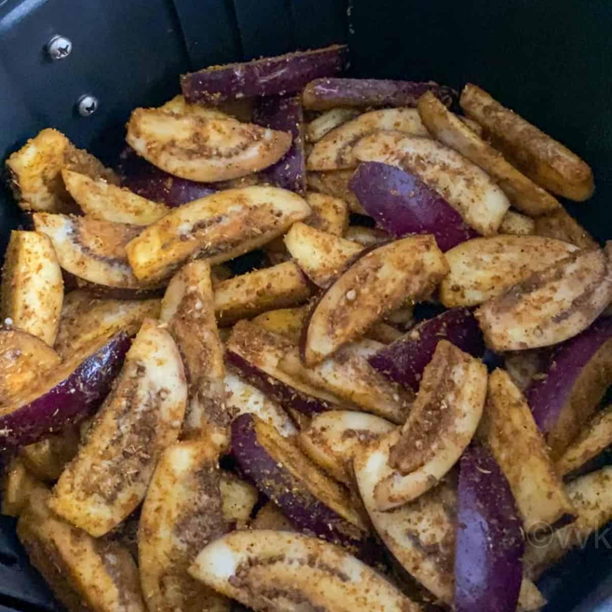 adding the spicy eggplant to the air fryer