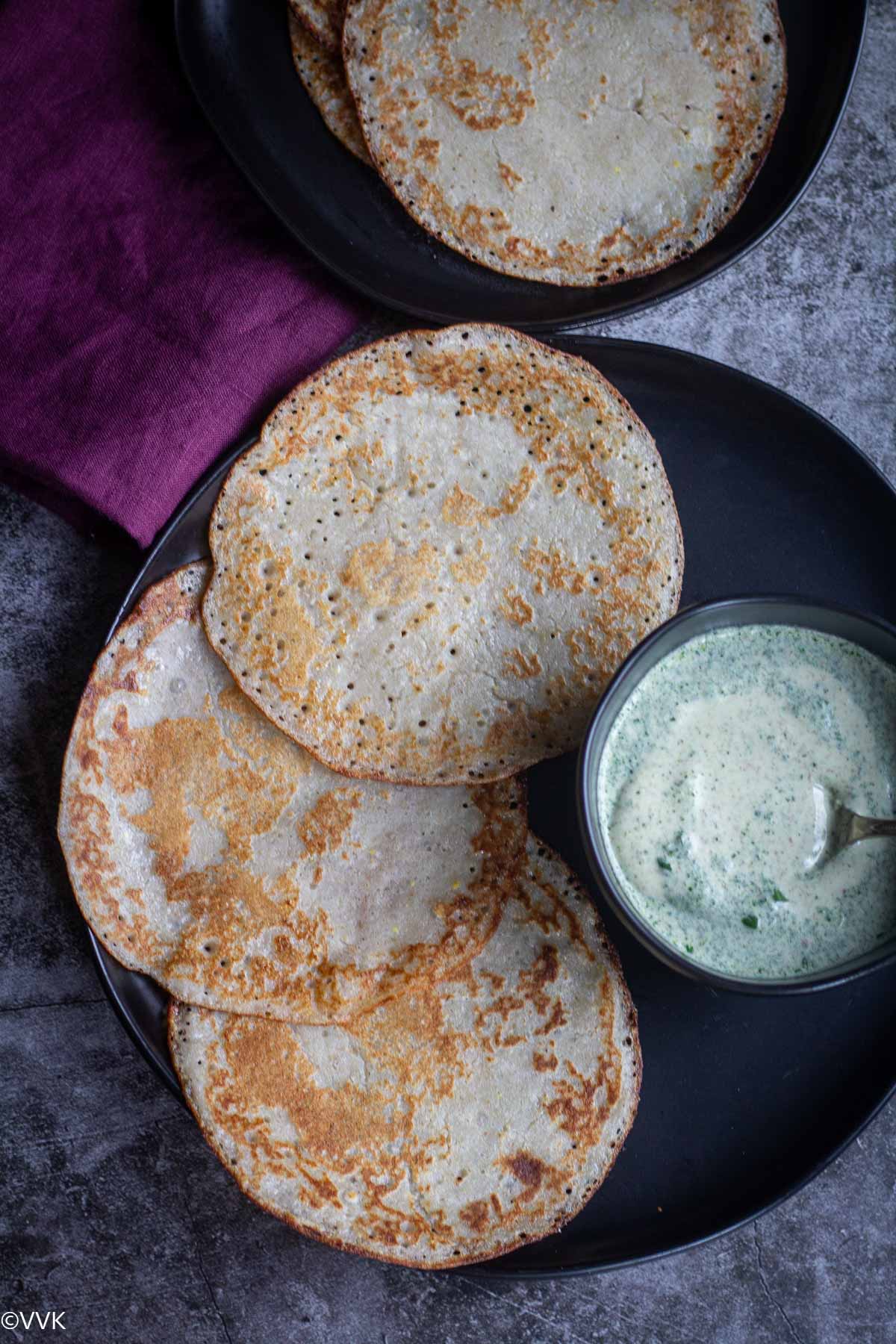 overhead shot of buckwheat dosa served in black plate with chutney