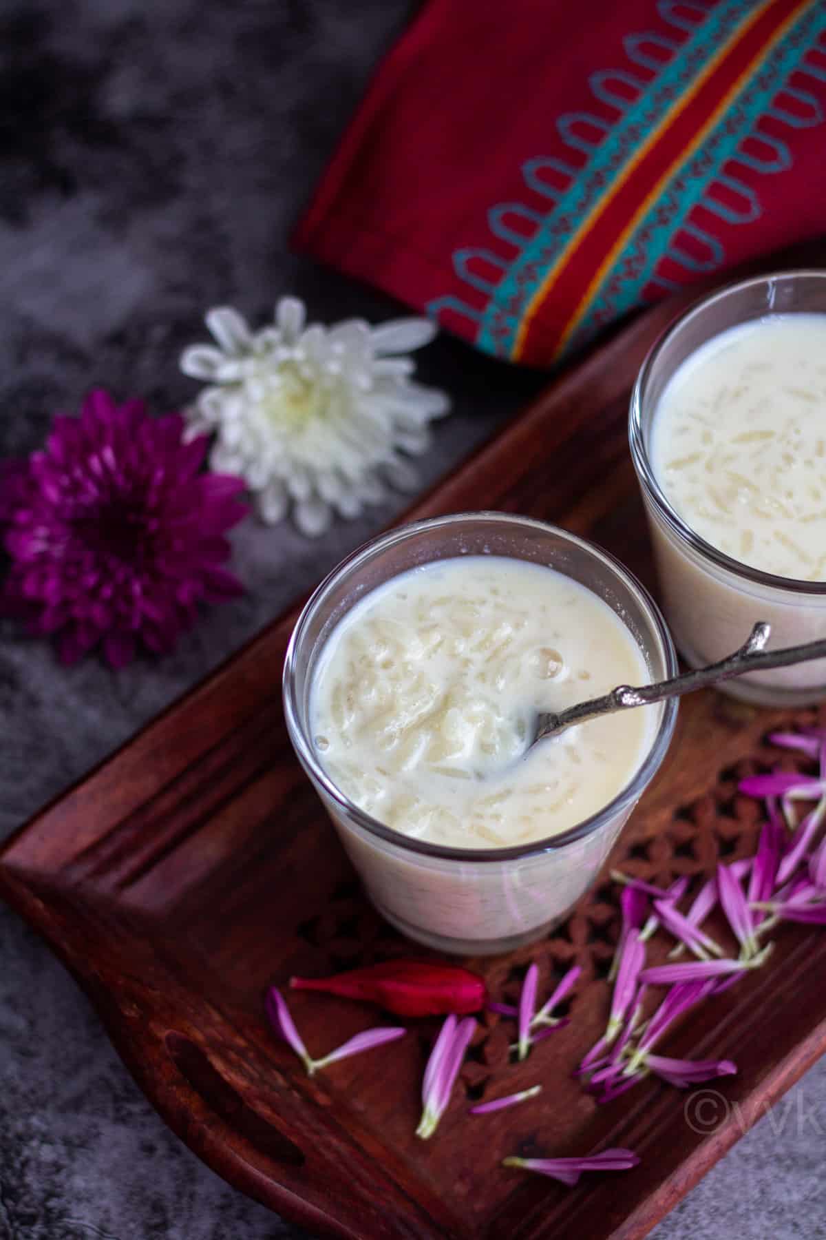 close up shot of paal payasam served in glass jars with spoon inside
