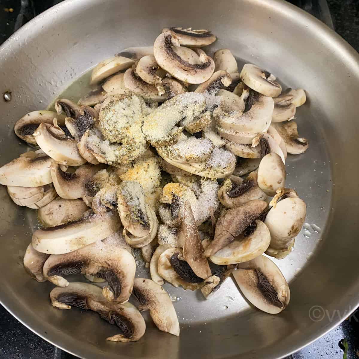 adding mushroom and spices to the sauce pan