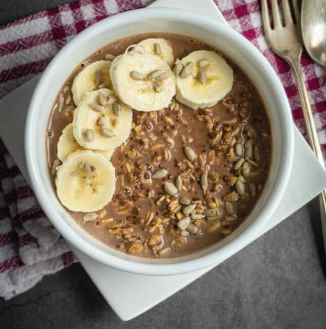 overhead shot of overnight oats served in a bowl with bananas and sunflower seeds