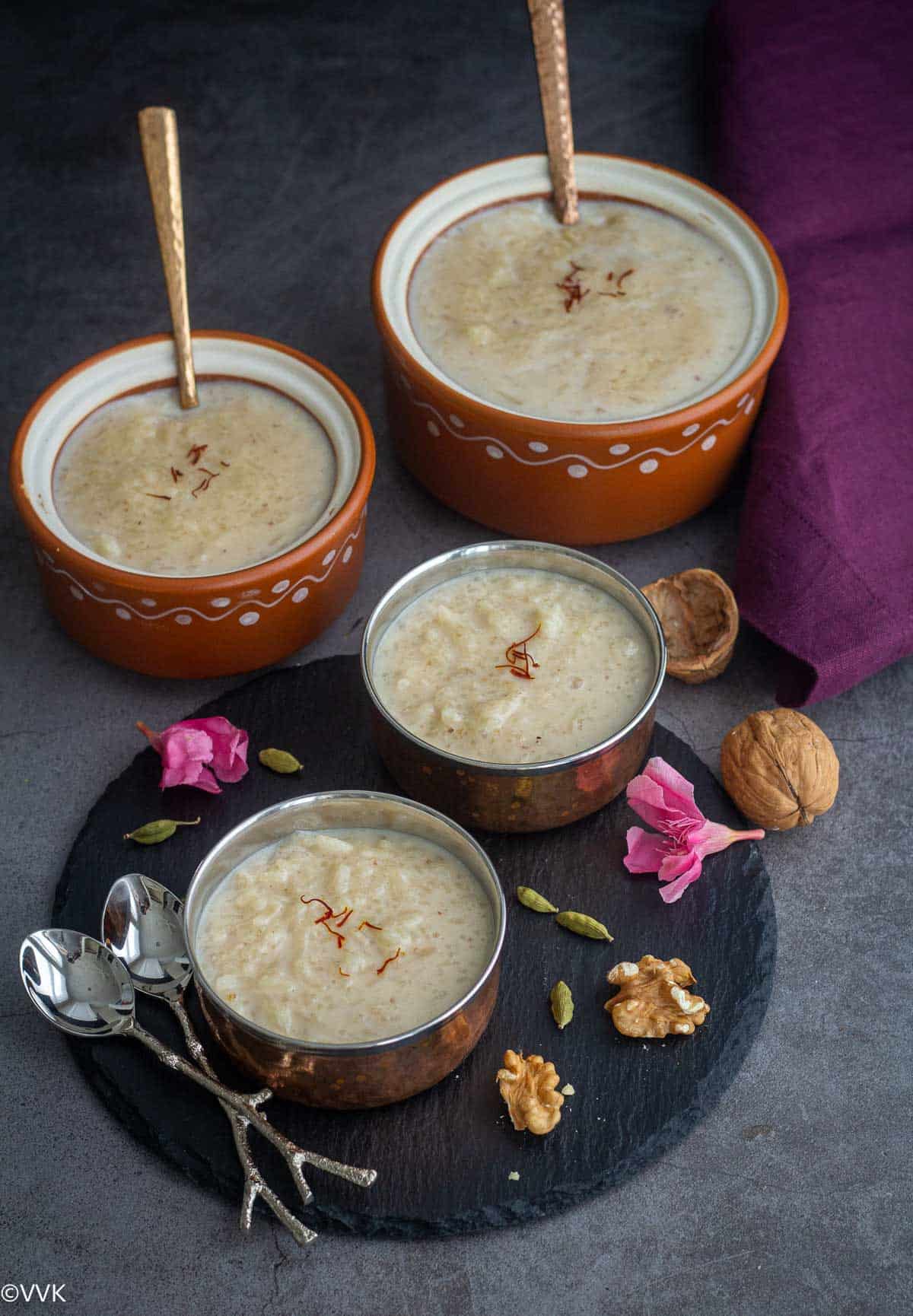 instant pot rice and walnut kheer served in bowls and also in traditional ceramic ware with some garnishes on the side